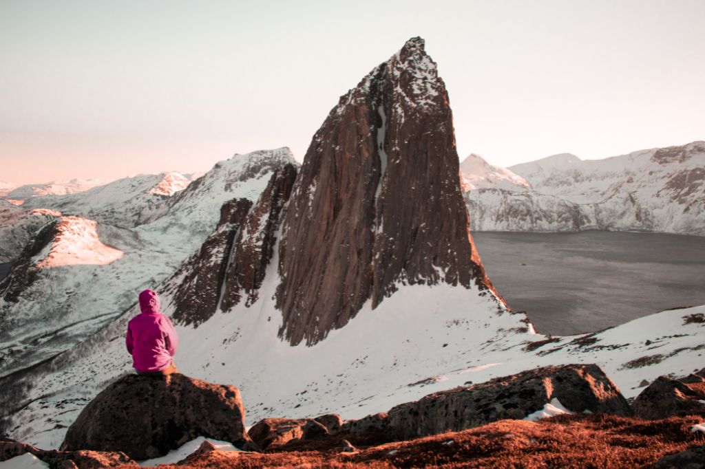 Man sitting on a rock near snowy mountains