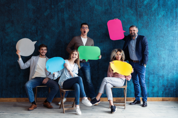 A marketing team photo holding text balloon signs