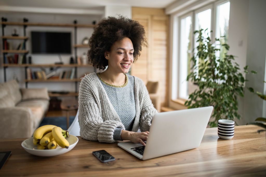 A female contractor writing a blog post on a laptop at home