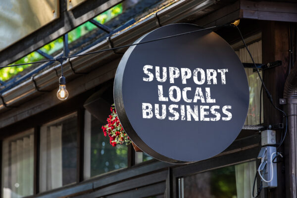 a sign outside a shop that says support local business