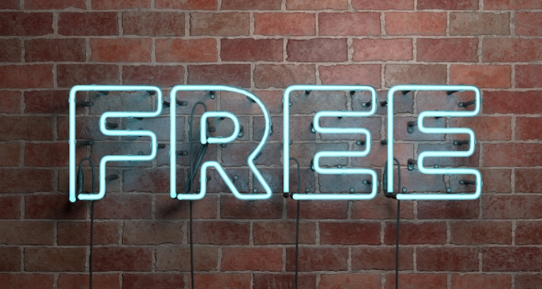 The word Free written in neon letters on a brick wall